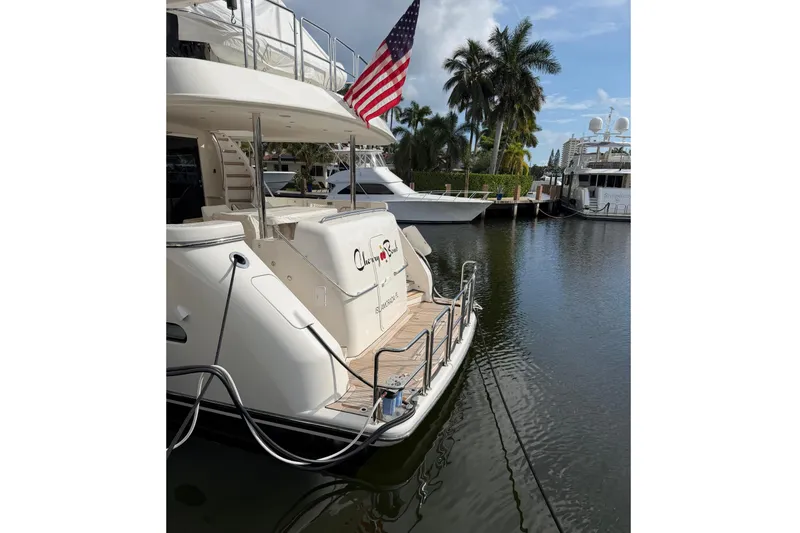 Slide: The Image of 2014 Pacific Mariner 85 Motor Yacht docked, featuring American flag and serene marina setting. - 5