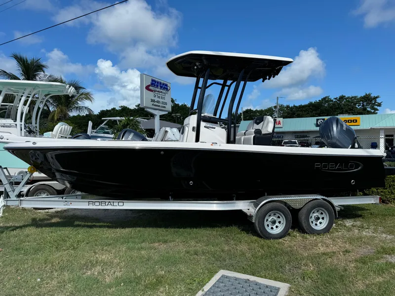 The Image of 2024 Robalo 226 Cayman boat on trailer, displayed outdoors under blue sky. - 0