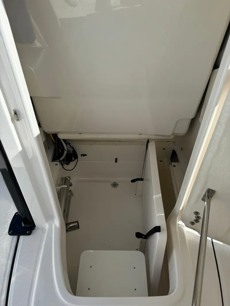 Slide: The Image of 2024 Robalo 226 Cayman interior cabin with white seating and storage space. - 16