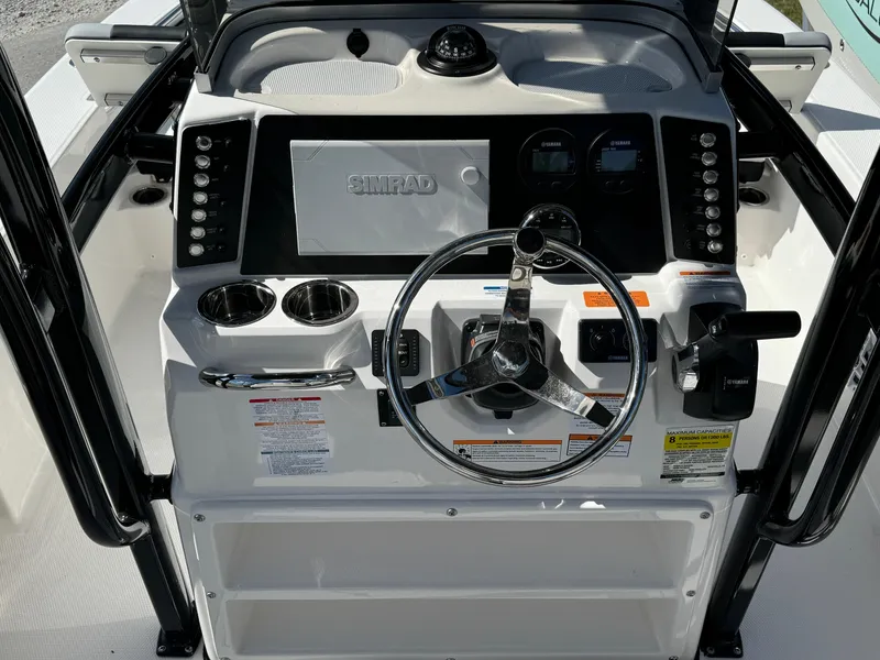 Slide: The Image of 2024 Robalo 226 Cayman boat dashboard with steering wheel and controls. - 6