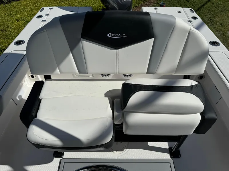 Slide: The Image of 2024 Robalo 226 Cayman boat seating, white and black upholstery, outdoor setting. - 8