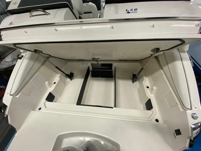 Slide: The Image of 2025 Regal LX6 boat storage compartment with open hatch, showcasing spacious interior design. - 16