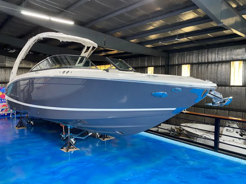 The Image of 2025 Regal LX6 boat displayed indoors on a blue floor. - 2