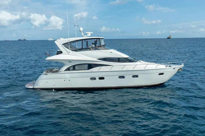 The Image of Luxury 2006 Marquis 59 yacht cruising on open sea under clear blue sky. - 0