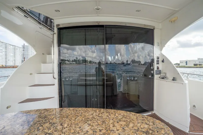 Slide: The Image of 2006 Marquis 59 yacht interior with granite table, glass doors, and ocean view. - 12