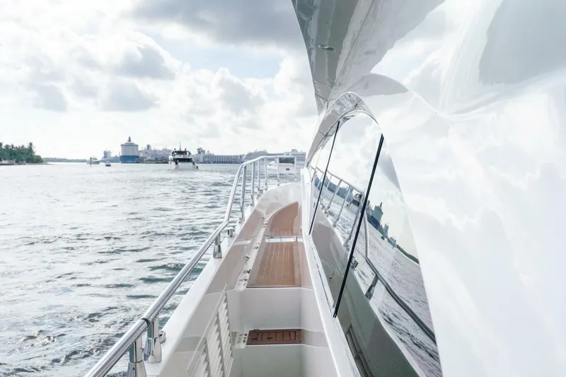 Slide: The Image of 2006 Marquis 59 yacht cruising on a sunny day with cityscape in background. - 16