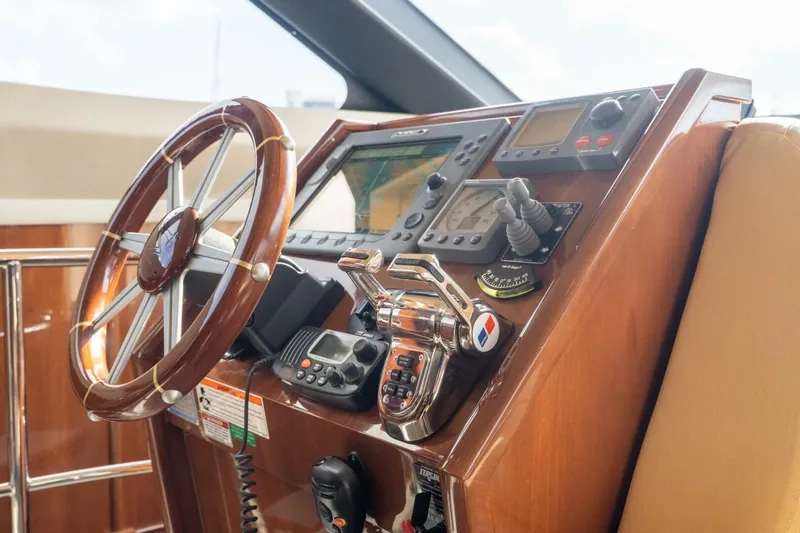 Slide: The Image of 2006 Marquis 59 yacht helm with wooden steering wheel and navigation controls. - 18