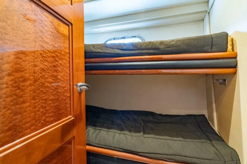 Slide: The Image of 2006 Marquis 59 yacht interior with wooden door and cozy bunk beds. - 24
