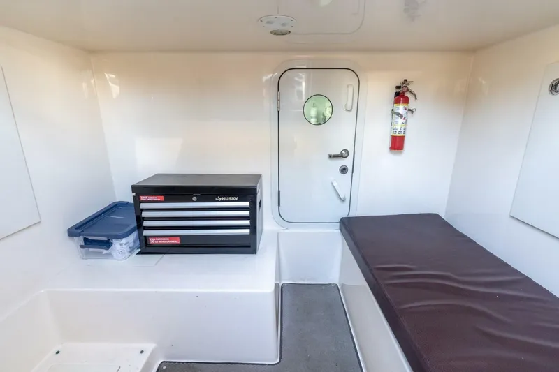 Slide: The Image of Interior of 2006 Marquis 59 yacht with toolbox, fire extinguisher, and cushioned bench. - 32