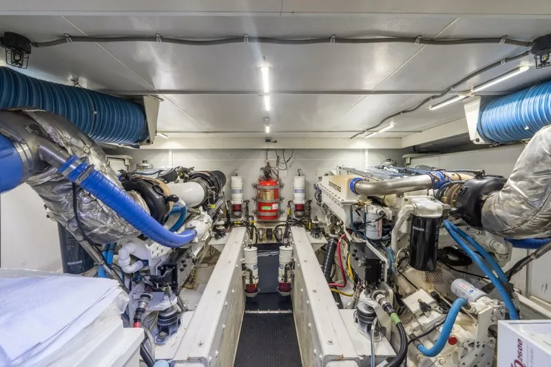 Slide: The Image of Engine room of a 2006 Marquis 59 yacht, featuring dual engines and ventilation systems. - 33