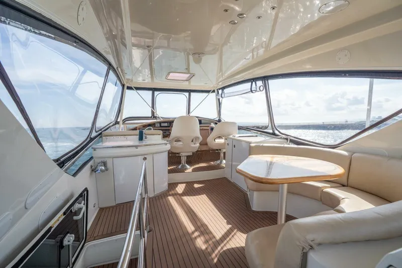 Slide: The Image of Luxurious 2006 Marquis 59 yacht interior with elegant seating and panoramic ocean views. - 9