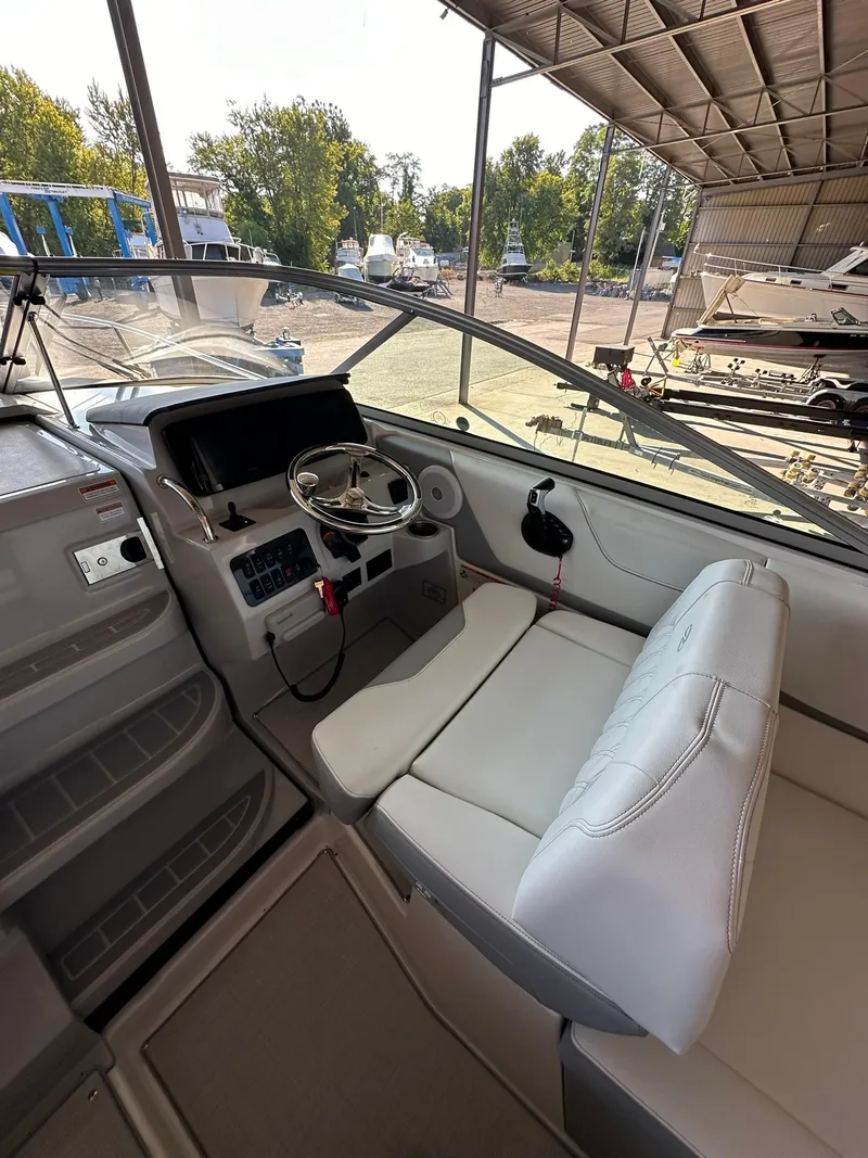 Slide: The Image of 2025 Regal 26XO boat interior with steering wheel and seating in a marina setting. - 18