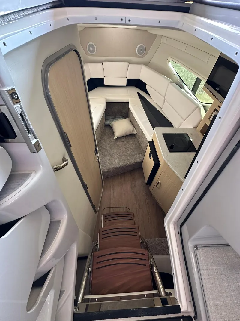 Slide: The Image of 2025 Regal 26XO boat interior with modern seating and compact kitchenette. - 22