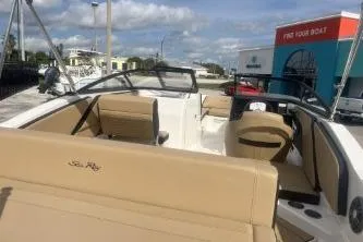 Slide: The Image of 2017 Sea Ray SPX 210 Outboard boat with beige seating, docked under a partly cloudy sky. - 6