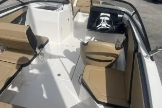 Slide: The Image of 2017 Sea Ray SPX 210 Outboard interior with beige seating and steering console. - 7