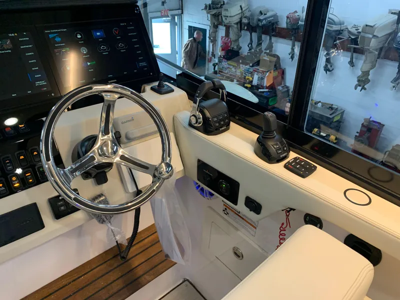 Slide: The Image of 2023 Regal 36XO boat helm with steering wheel and control panel. - 14