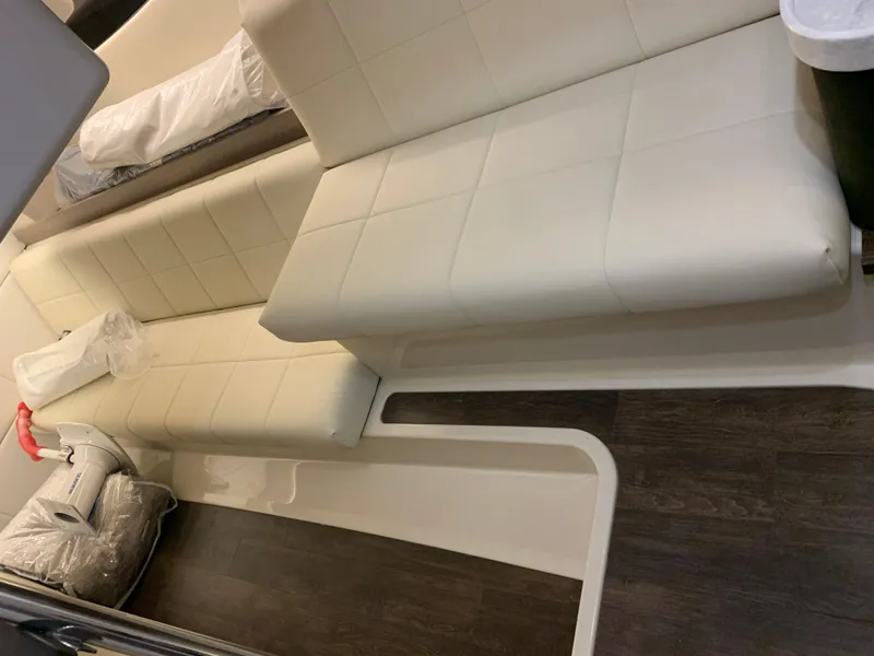 Slide: The Image of 2023 Regal 36XO boat interior with white leather seating and dark wood flooring. - 23