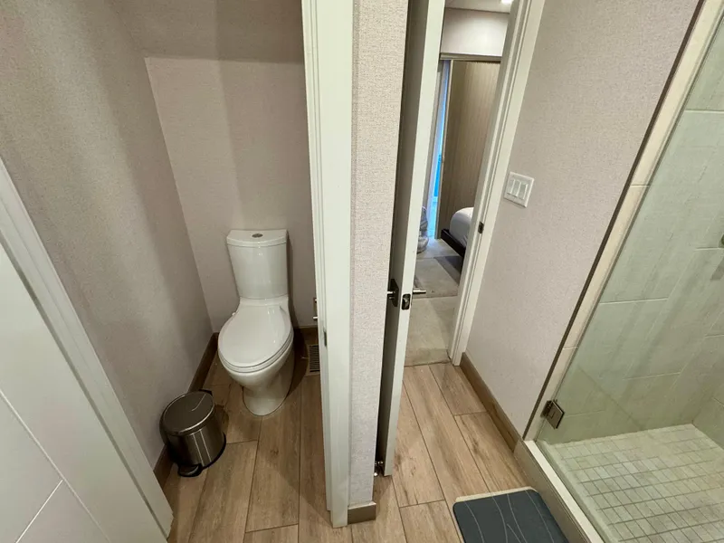 Slide: The Image of Modern bathroom in Adonia Pace Trip #7 RV, featuring toilet, shower, and wooden flooring. - 21