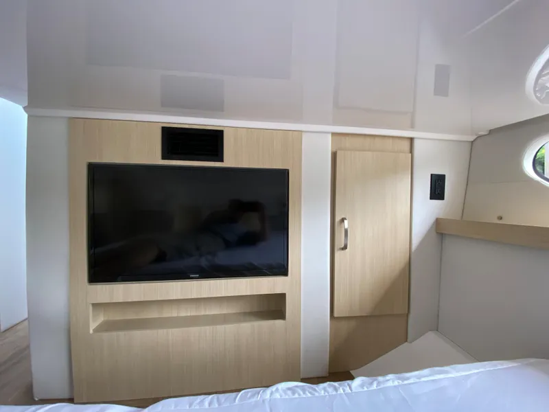 Slide: The Image of 2024 Regal 38XO yacht interior with mounted TV and wooden cabinetry. - 20