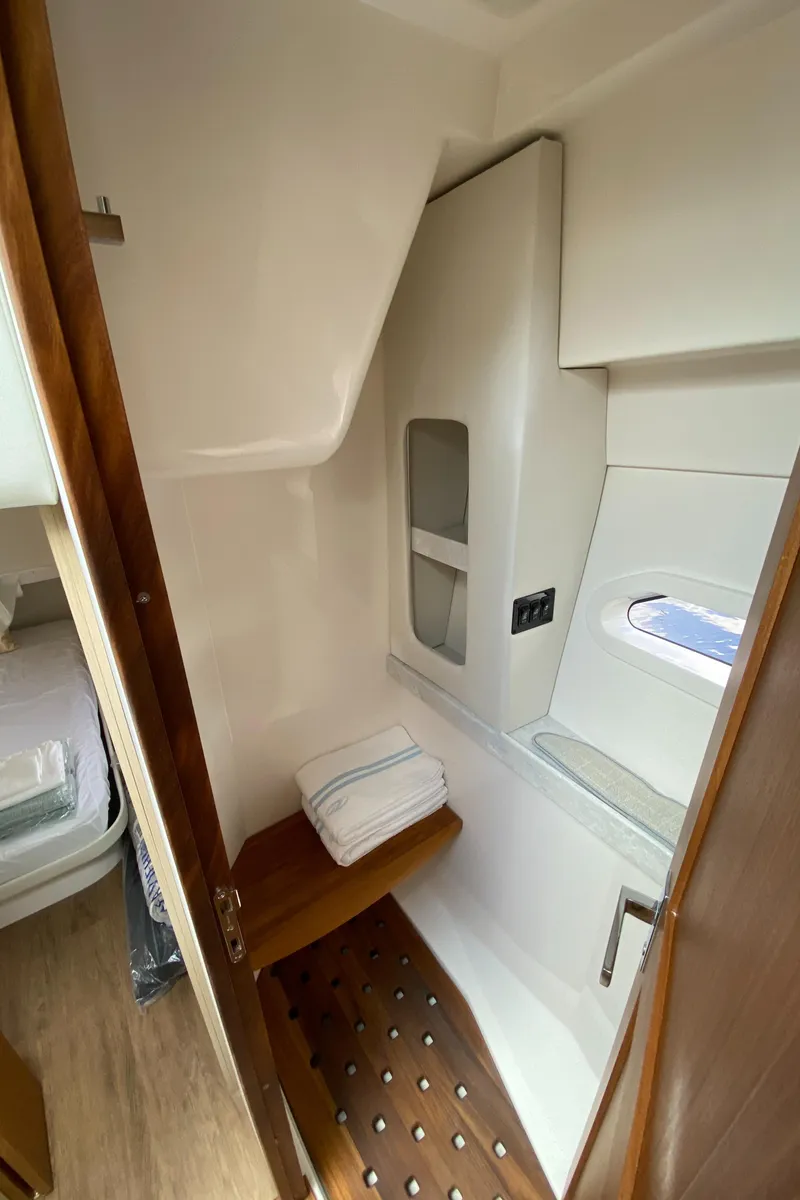 Slide: The Image of 2024 Regal 38XO yacht interior bathroom with wooden accents and window. - 23