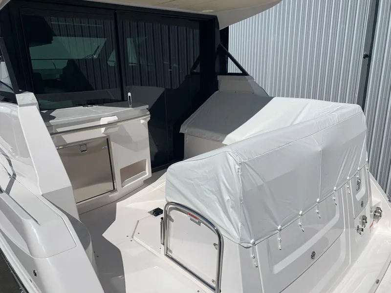 Slide: The Image of 2024 Regal 38XO yacht stern view with covered seating and outdoor kitchen. - 5