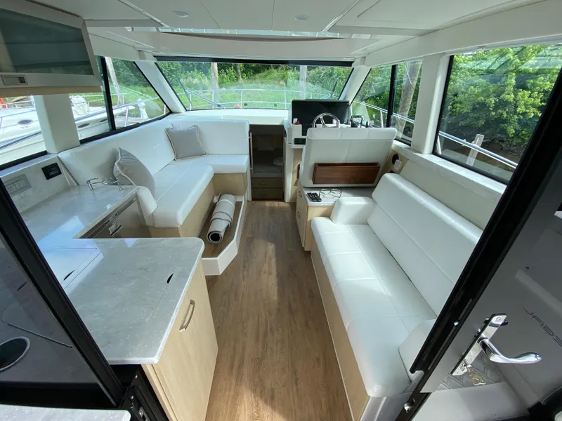 Slide: The Image of Interior of 2024 Regal 38XO yacht with modern seating and panoramic windows. - 8