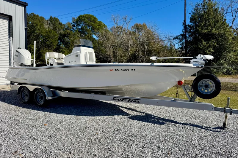 The Image of 2023 BlackJack 256 Bay boat on trailer, parked outdoors near trees. - 1
