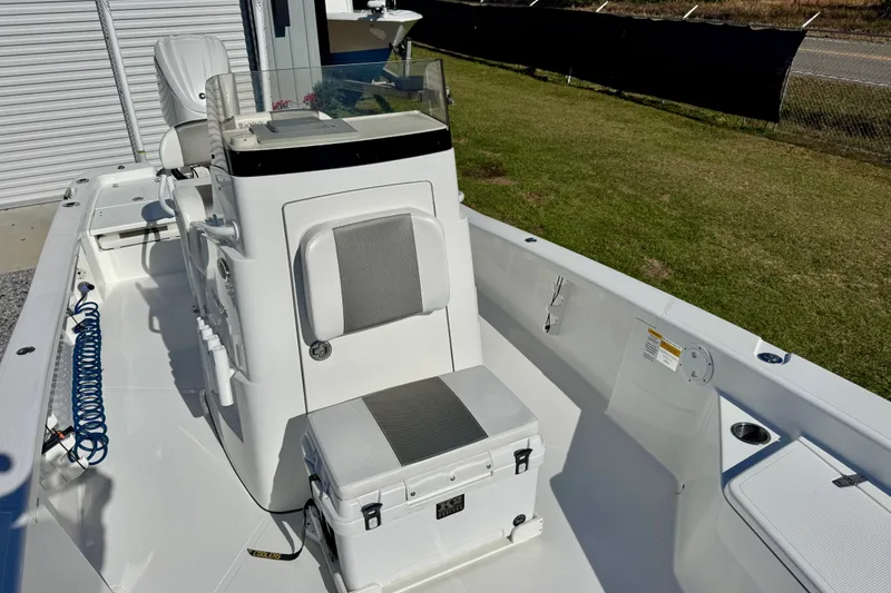Slide: The Image of 2023 BlackJack 256 Bay boat interior with seating and console, parked outdoors. - 7