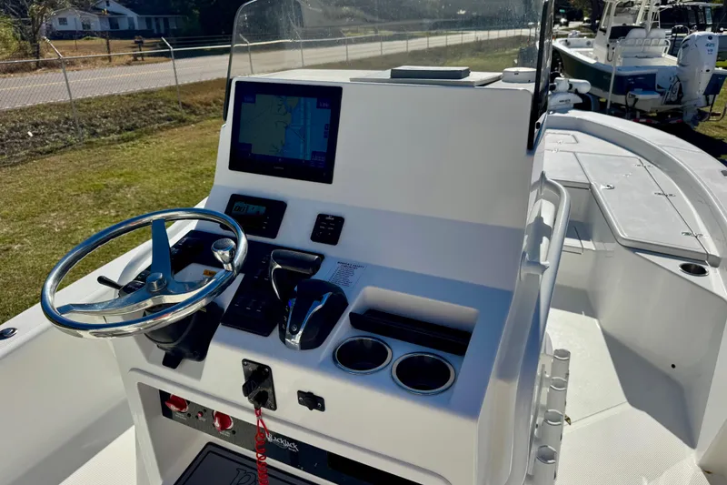Slide: The Image of 2023 BlackJack 256 Bay boat console with steering wheel and navigation display. - 9