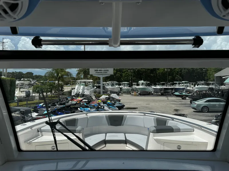 Slide: The Image of 2025 Robalo R360 Center Console boat view from cockpit, showcasing marina and parked watercraft. - 18
