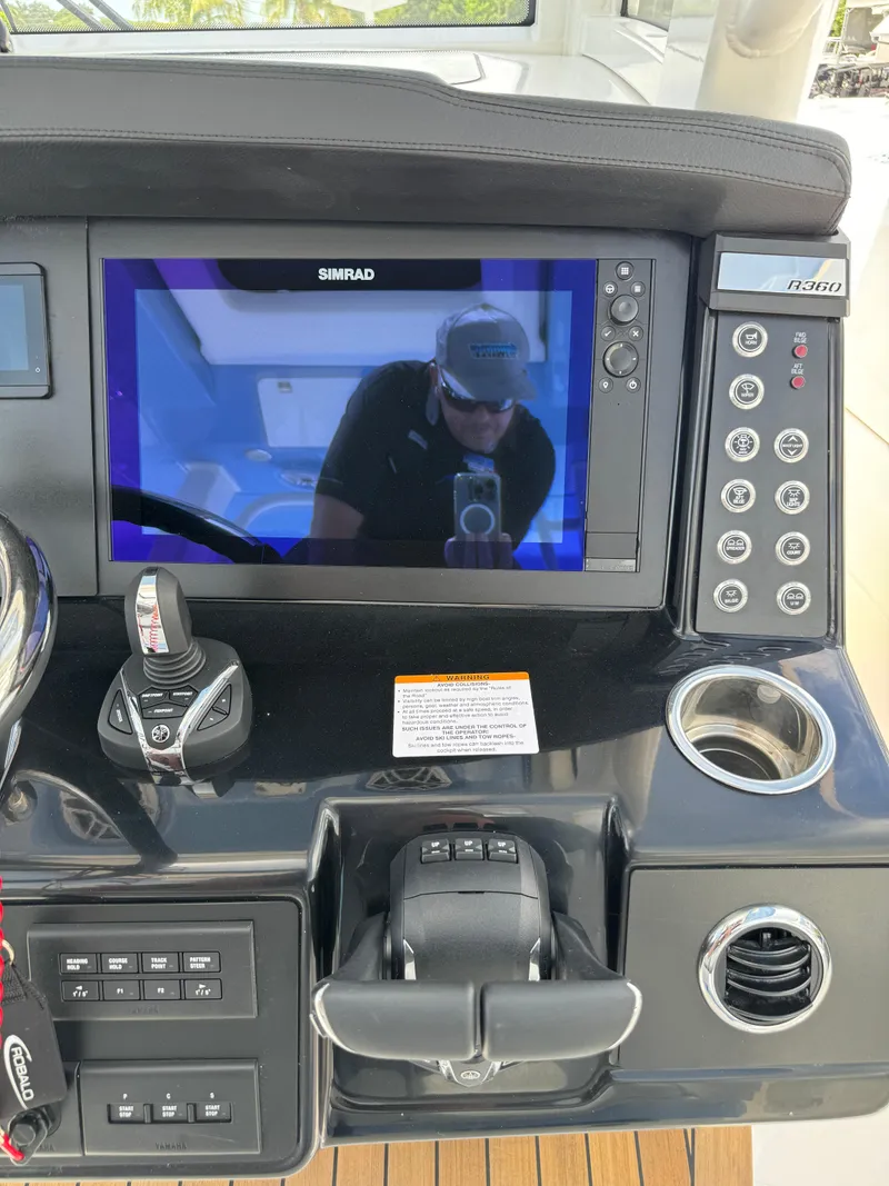 Slide: The Image of 2025 Robalo R360 Center Console dashboard with Simrad display and control panel. - 23