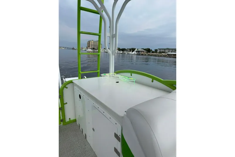 Slide: The Image of Aloha Pontoon 300, 2026 model, on calm waters with green accents and seating. - 3