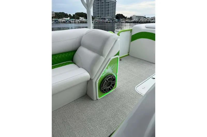 Slide: The Image of 2026 Aloha Pontoon 300 interior with white and green seating, speaker, and waterfront view. - 4