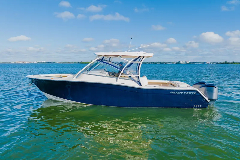 The Image of 2013 Grady-White Freedom 335 boat on calm water under blue sky. - 0