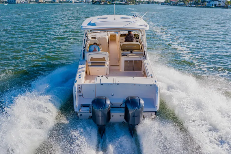Slide: The Image of 2013 Grady-White Freedom 335 boat cruising on open water, rear view. - 19