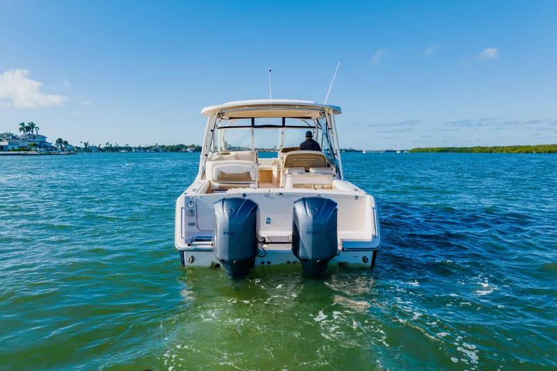 Slide: The Image of 2013 Grady-White Freedom 335 boat cruising on clear blue water. - 2