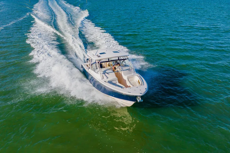 Slide: The Image of 2013 Grady-White Freedom 335 boat cruising on open water, creating a wake. - 20