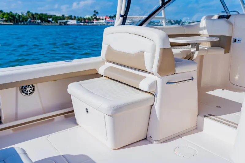Slide: The Image of 2013 Grady-White Freedom 335 boat interior with seating and table, on a sunny day. - 31