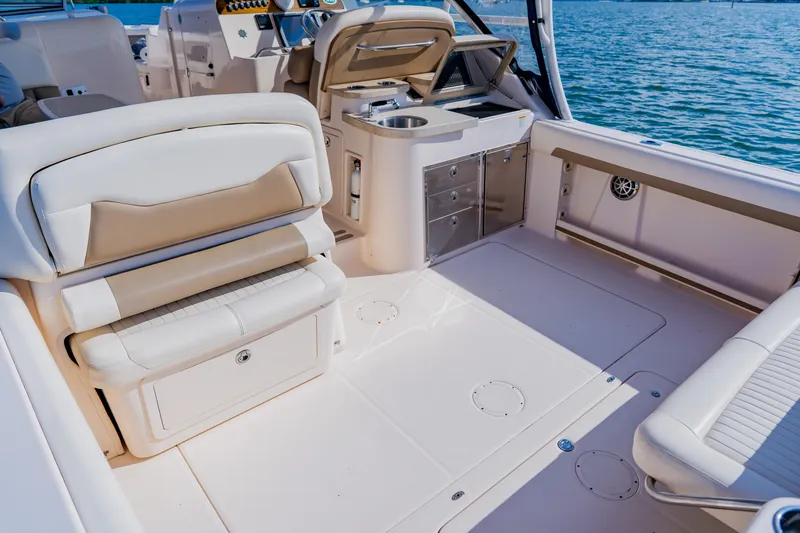 Slide: The Image of 2013 Grady-White Freedom 335 boat interior with seating and storage, on calm water. - 35