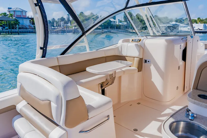 Slide: The Image of 2013 Grady-White Freedom 335 boat interior with seating and table, dockside view. - 40