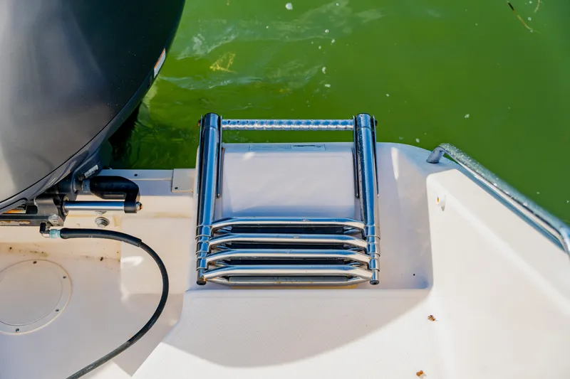 Slide: The Image of Stainless steel ladder on 2013 Grady-White Freedom 335 boat, near green water. - 57