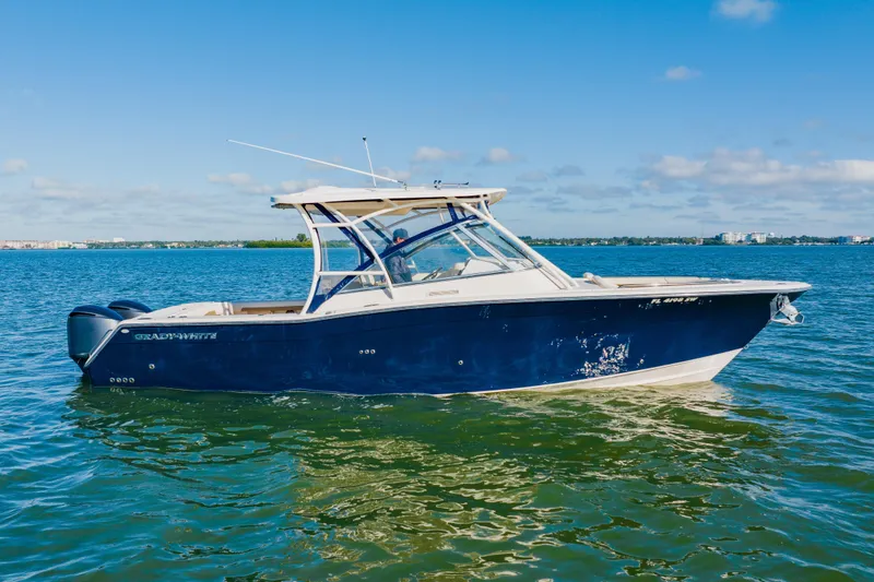 Slide: The Image of 2013 Grady-White Freedom 335 boat on calm water under clear blue sky. - 8