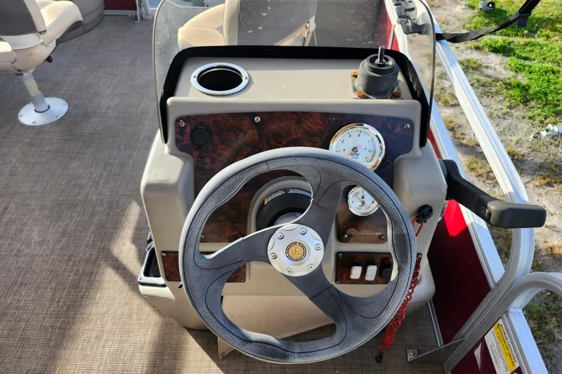 Slide: The Image of 2023 Sun Tracker Bass Buggy 18 DLX steering console with gauges and controls. - 14