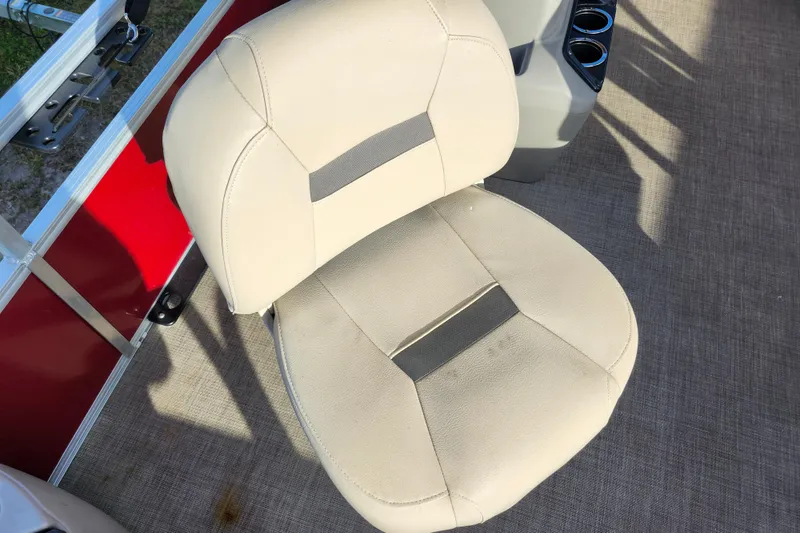 Slide: The Image of 2023 Sun Tracker Bass Buggy 18 DLX boat seat, beige upholstery, red panel background. - 22