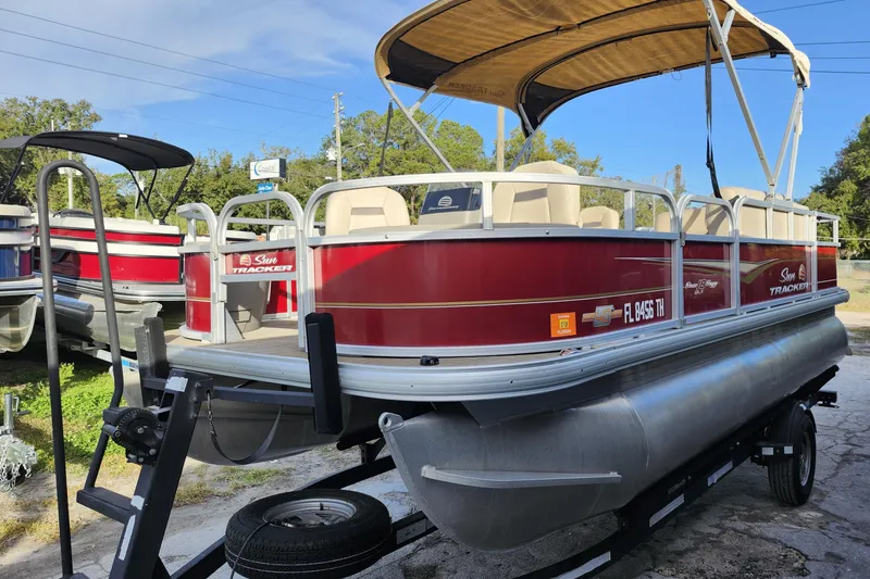 Slide: The Image of 2023 Sun Tracker Bass Buggy 18 DLX pontoon boat on trailer, red and silver design. - 3