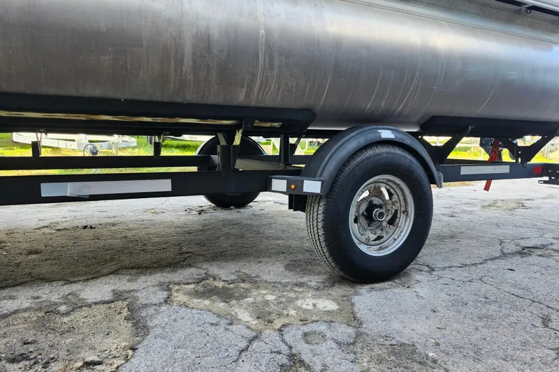 Slide: The Image of 2023 Sun Tracker Bass Buggy 18 DLX trailer, close-up of wheel and undercarriage. - 34