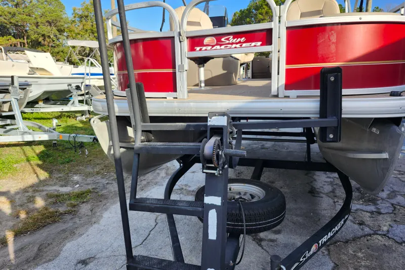 Slide: The Image of 2023 Sun Tracker Bass Buggy 18 DLX pontoon boat on trailer, parked outdoors. - 39
