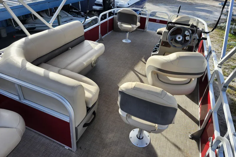 Slide: The Image of 2023 Sun Tracker Bass Buggy 18 DLX pontoon boat interior with beige seating and steering console. - 7