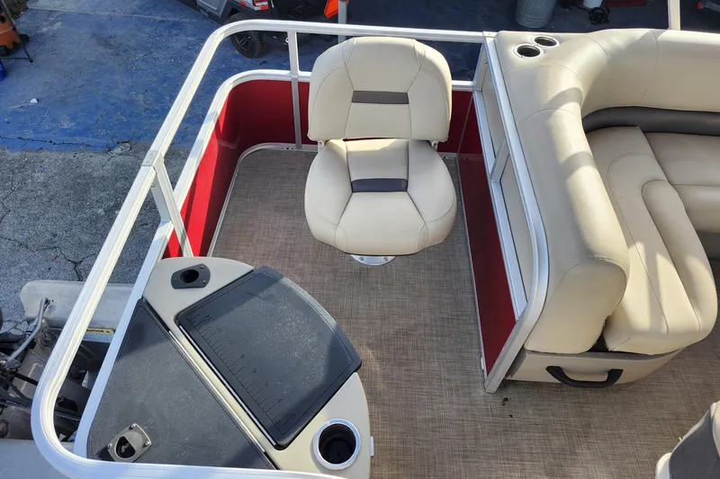 Slide: The Image of 2023 Sun Tracker Bass Buggy 18 DLX interior with beige seating and red accents. - 8
