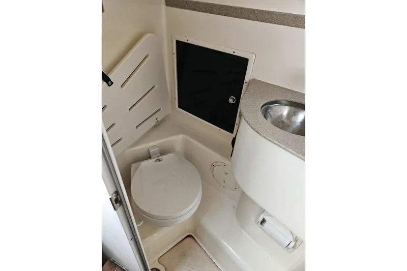 Slide: The Image of 2000 Pursuit 3070 Offshore Center Console boat interior with toilet and sink. - 7